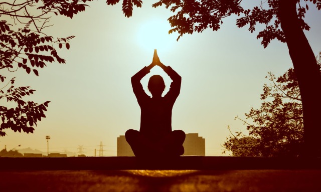 Fotoğrafta, meditasyon yapan bir kişinin namaste pozisyonunu görmektesiniz.